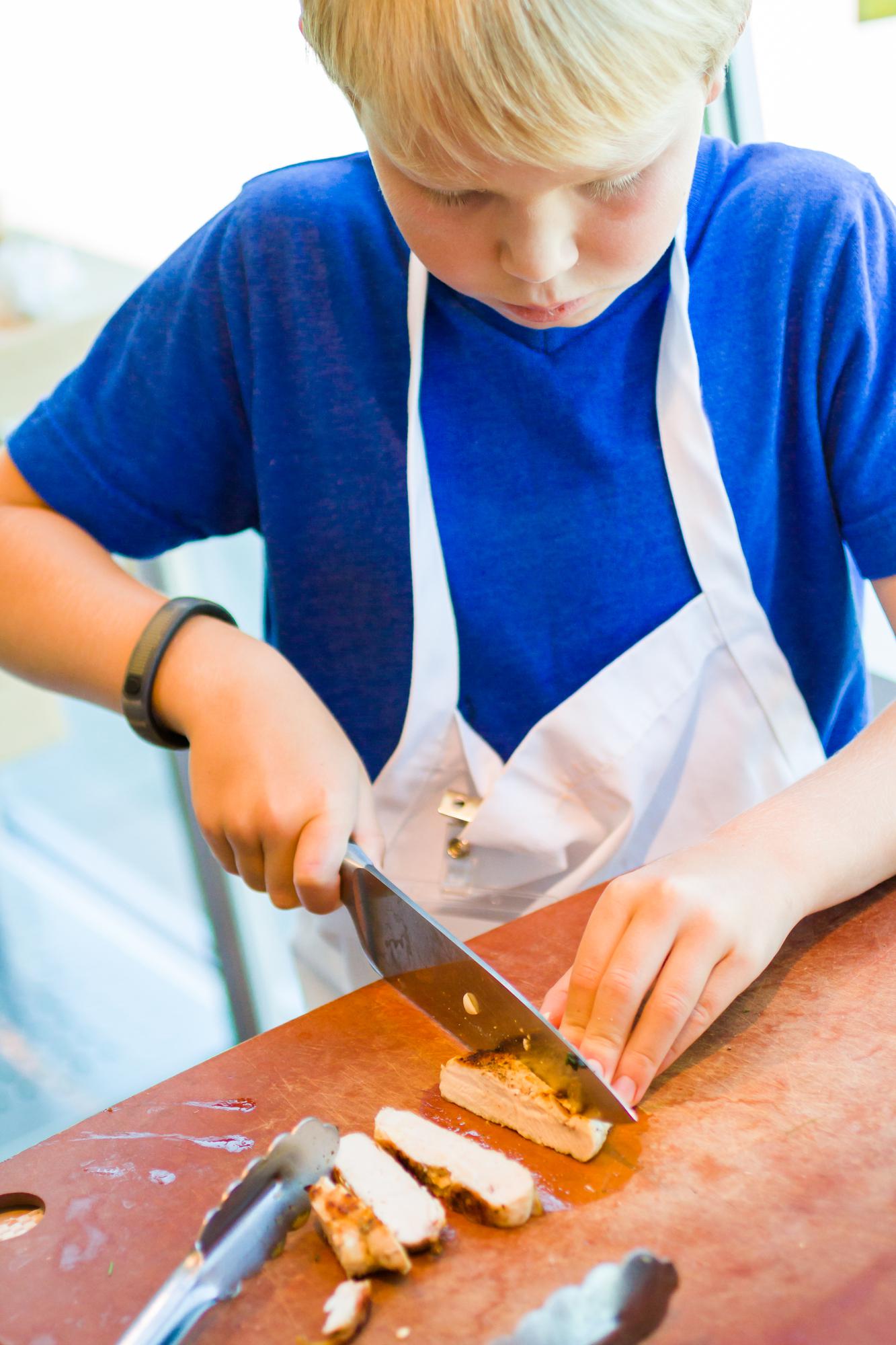 Students around table learning knife skills