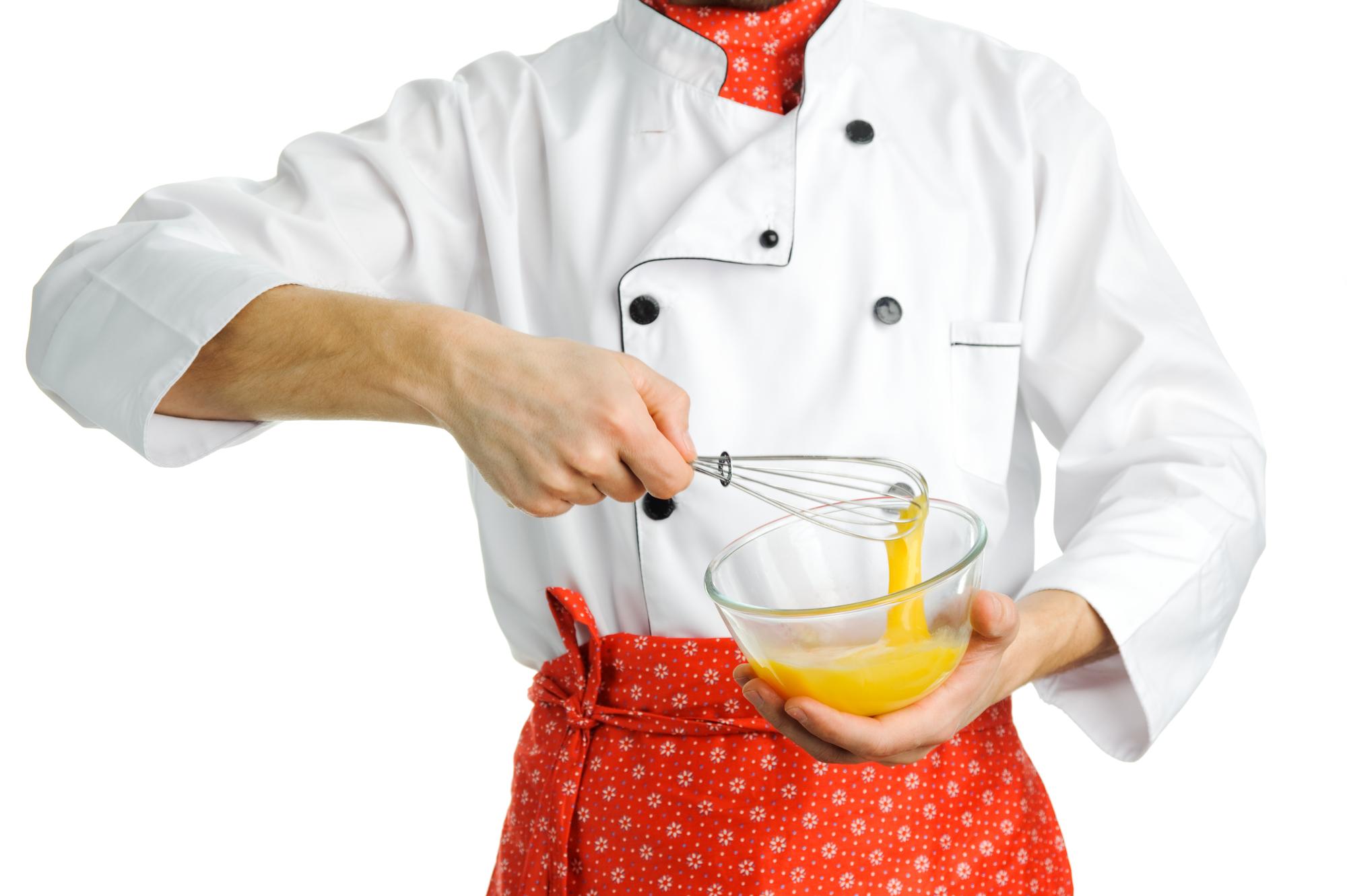 Chef demonstrating a plated dish in warm studio